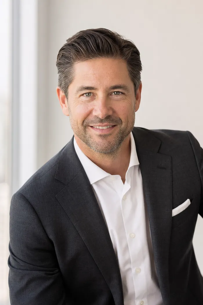 Polished headshot of a man in a charcoal suit